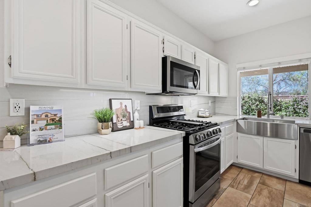 5051 Lake Circle Road Fallbrook, CA 92028 - Photo 12 of 50 a kitchen with stainless steel appliances granite countertop white cabinets a stove a sink and a white wooden cabinets