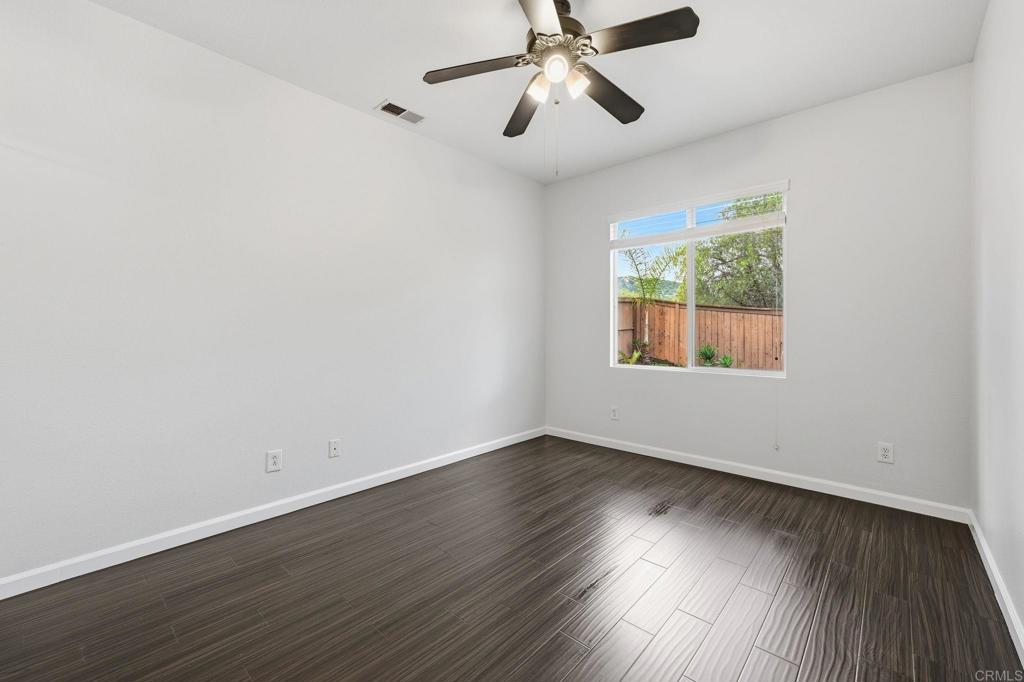 5051 Lake Circle Road Fallbrook, CA 92028 - Photo 21 of 57 a view of an empty room with wooden floor and a window