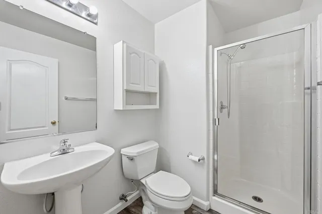 a view of empty room with wooden floor and ceiling fan