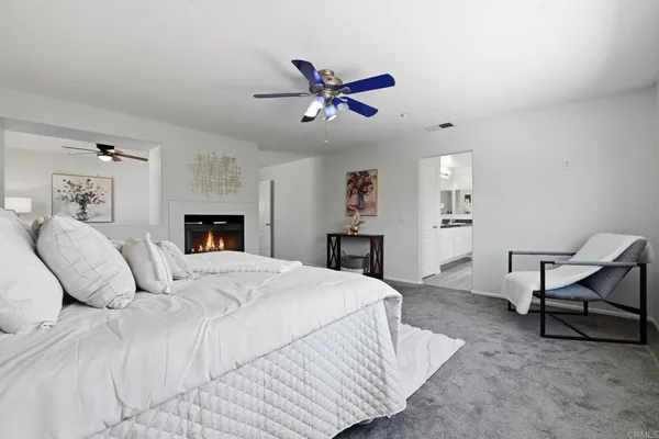 a spacious bedroom with a bed a couch and a chandelier
