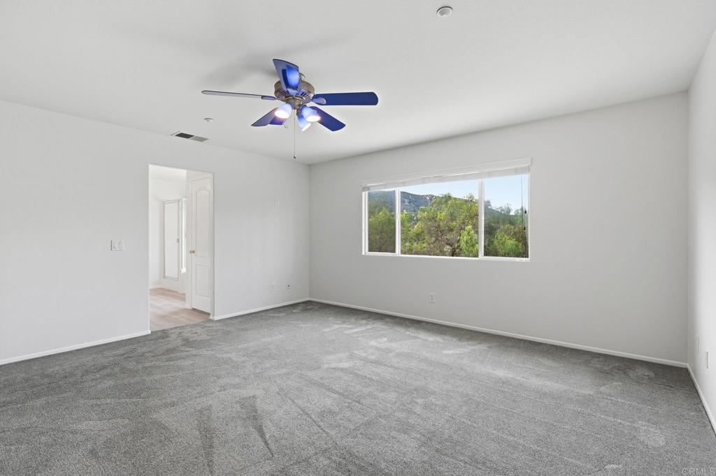 5051 Lake Circle Road Fallbrook, CA 92028 - Photo 34 of 57 an empty room with chandelier fan and windows