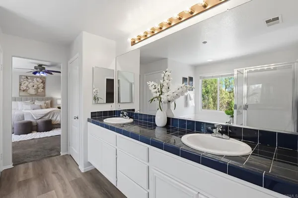 a bathroom with double vanity and a mirror