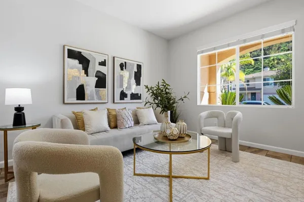 a living room with furniture a chandelier and a potted plant