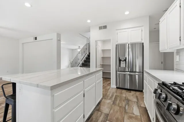 a kitchen with granite countertop a stove a sink dishwasher and a refrigerator
