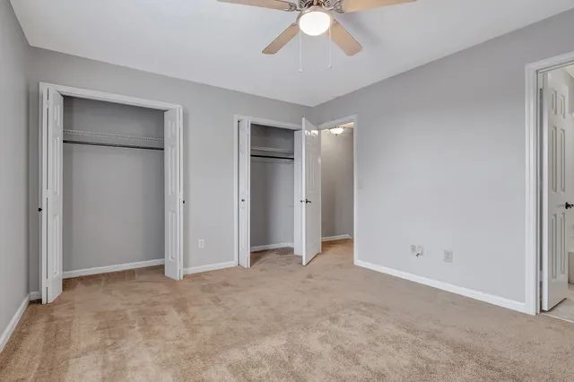 a view of an empty room with a chandelier fan