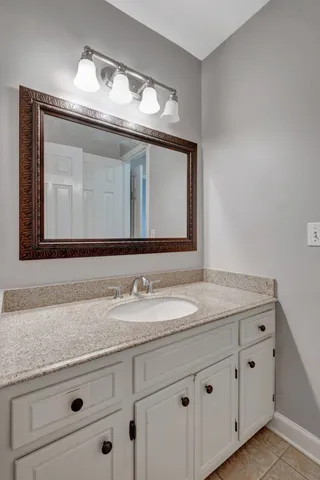 a bathroom with a granite countertop sink vanity and mirror