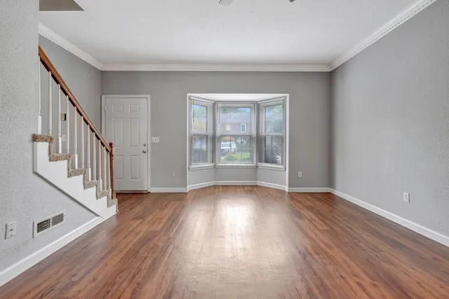 wooden floor in an empty room with a window