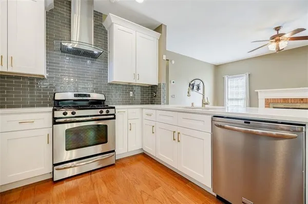a kitchen with granite countertop a stove a sink and a microwave