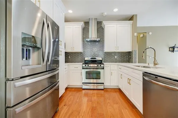 a kitchen with stainless steel appliances a stove sink and refrigerator