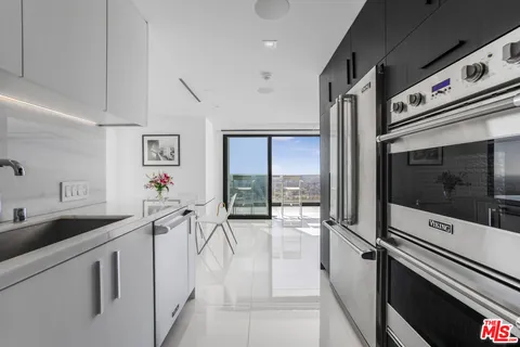 a kitchen with granite countertop a sink and white cabinets