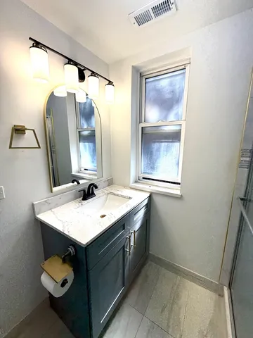 a bathroom with a sink vanity and mirror