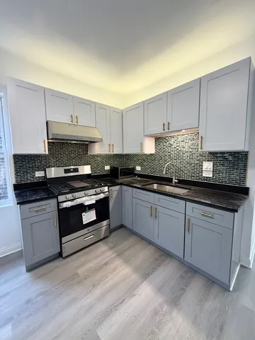 a kitchen with granite countertop white cabinets and stainless steel appliances
