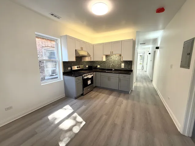 a large kitchen with stainless steel appliances granite countertop a stove and a refrigerator