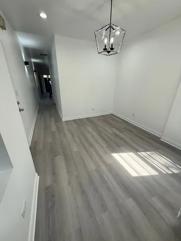 a view of a room with wooden floor and ceiling fan