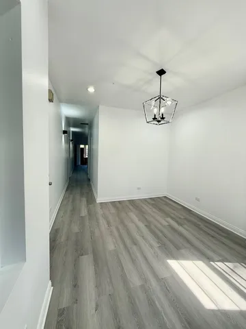 a view of a room with wooden floor and ceiling fan