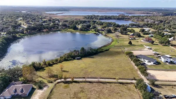 an aerial view of a house with a yard and lake view