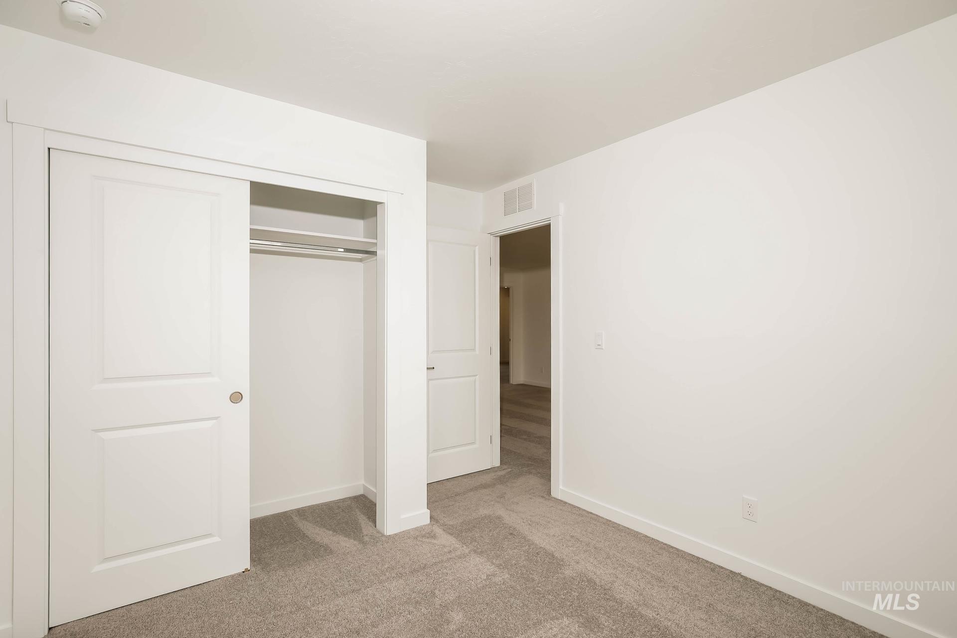 1918 East Springloyd Street Meridian, ID 83642 - Photo 15 of 20 Carpeted room with white walls, a built-in closet featuring sliding panel doors, and a clothing rod