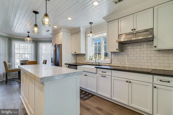 a kitchen with cabinets and chandelier