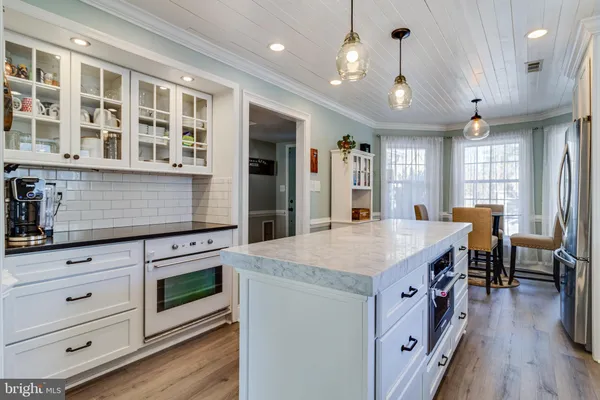 a kitchen with a stove and a wooden floor