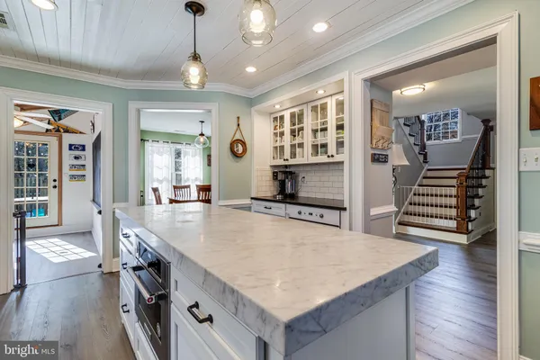 a large kitchen with kitchen island a stove a sink a dining table and chairs