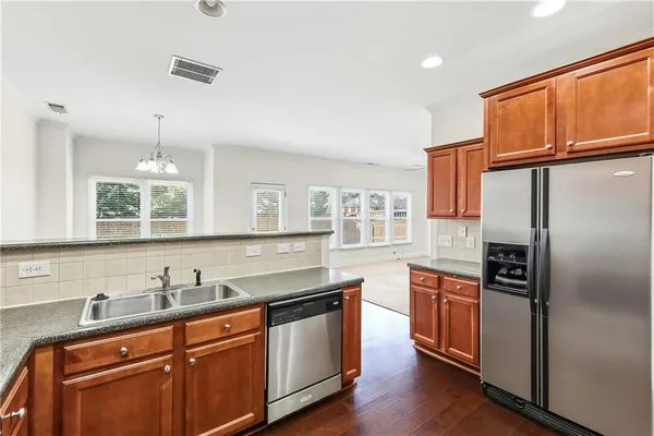 a kitchen with stainless steel appliances granite countertop a sink stove and refrigerator