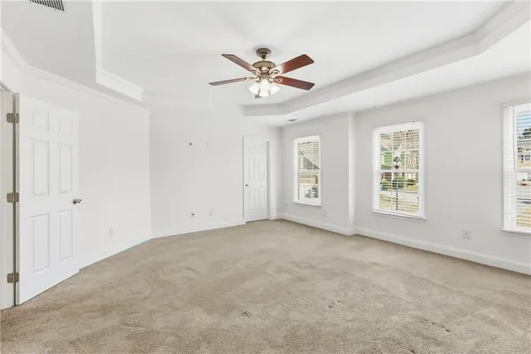 a view of an empty room with window and a ceiling fan