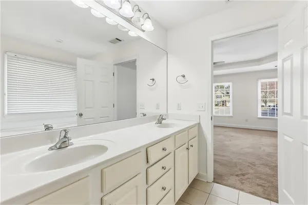a bathroom with double sink and a mirror