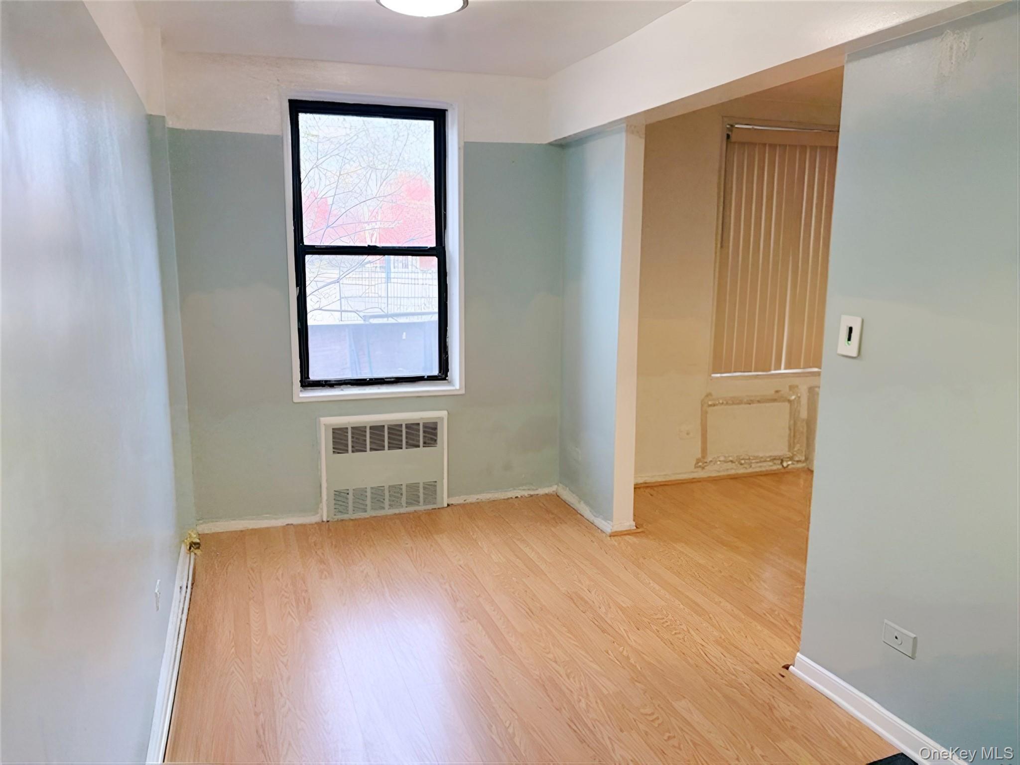 152-72 Melbourne Avenue, Unit 1D Queens, NY 11367 - Photo 3 of 14 an empty room with wooden floor and windows