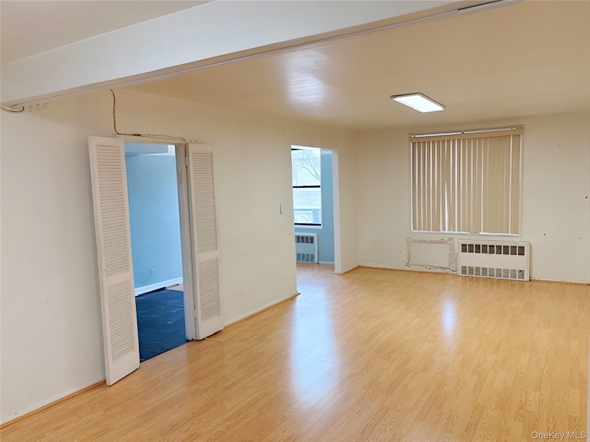 152-72 Melbourne Avenue, Unit 1D Queens, NY 11367 - Photo 4 of 14 a view of an empty room with wooden floor and a window