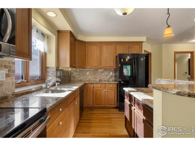 a kitchen with kitchen island granite countertop a sink stove and refrigerator