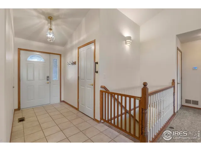 a view of a hallway with a chandelier fan and windows