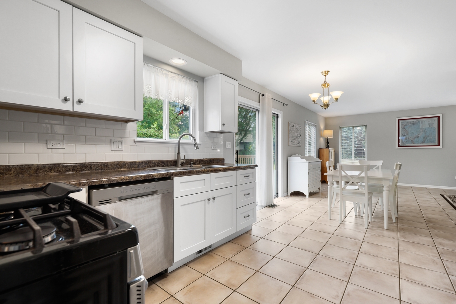 596 Buckboard Road Bolingbrook, IL 60490 - Photo 14 of 30 a kitchen with granite countertop a sink a stove a dining table and chairs