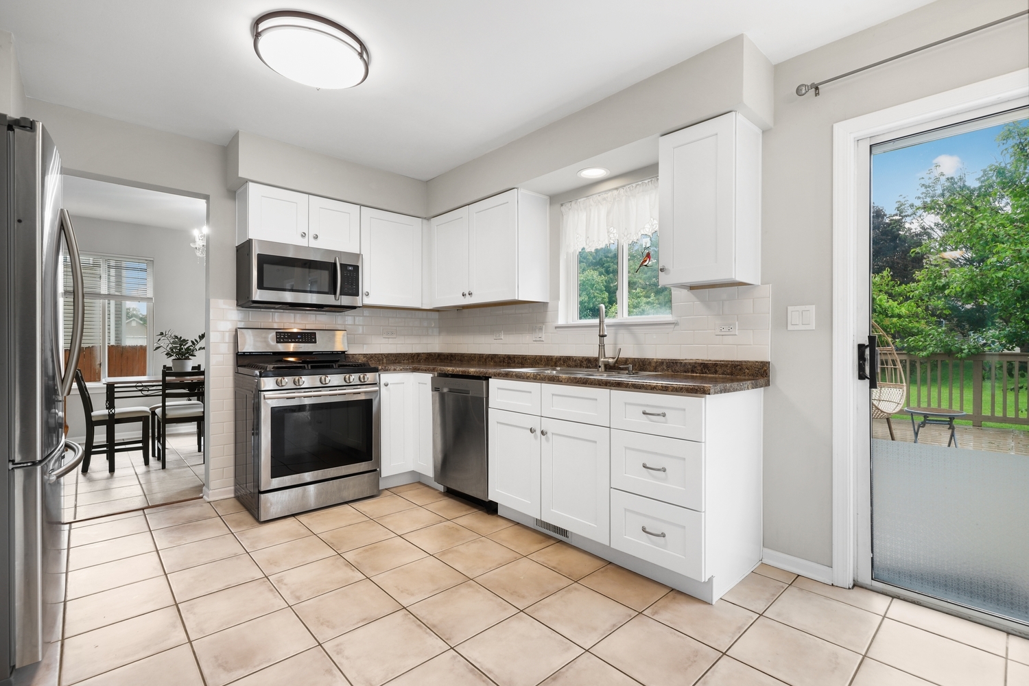 596 Buckboard Road Bolingbrook, IL 60490 - Photo 9 of 30 a kitchen with granite countertop a stove a sink and a microwave