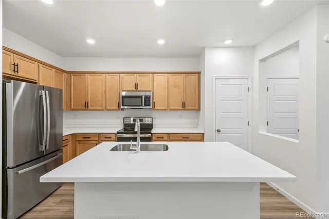 a kitchen with stainless steel appliances a refrigerator sink and microwave