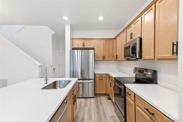 a kitchen with a sink a refrigerator and cabinets