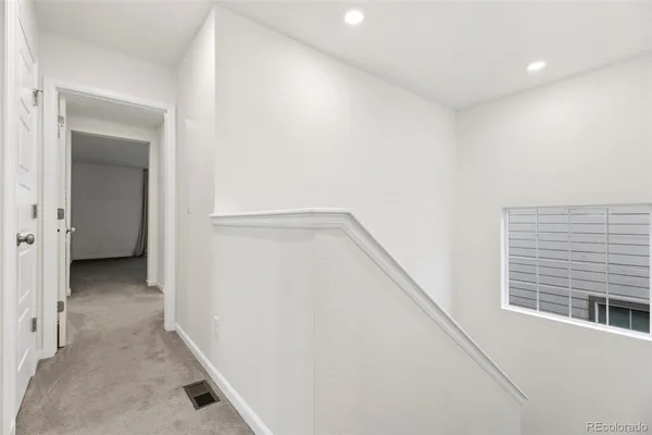 a view of a hallway with a closet and a window