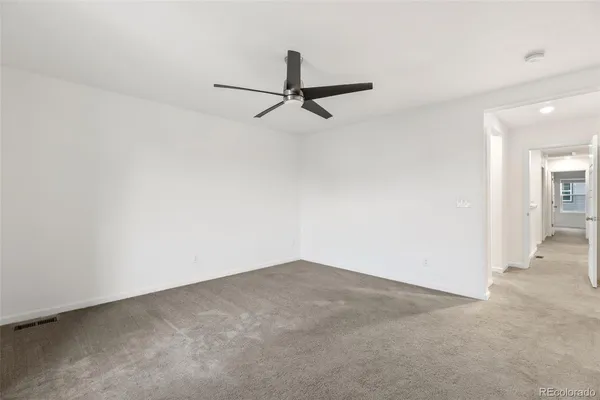 an empty room and chandelier fan