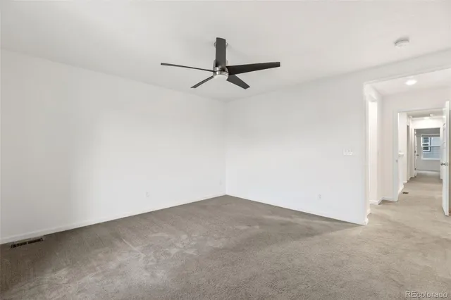 an empty room and chandelier fan