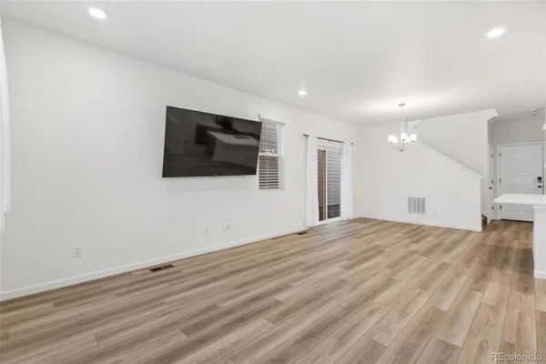 a view of a livingroom with wooden floor and flat screen tv