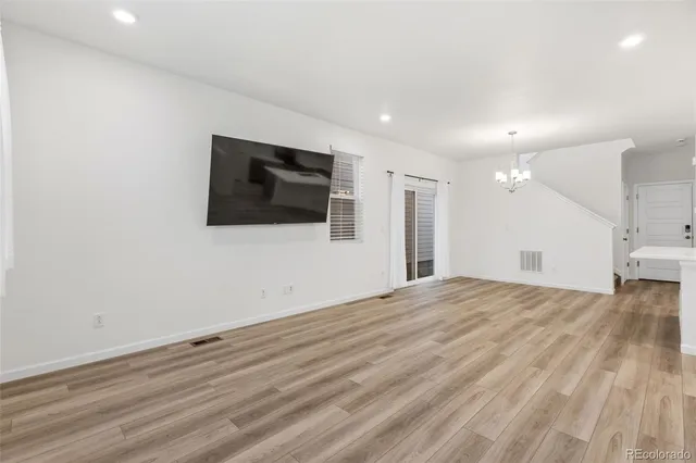 a view of a livingroom with wooden floor and flat screen tv