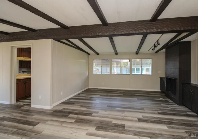 a view of an empty room with a fireplace and a window