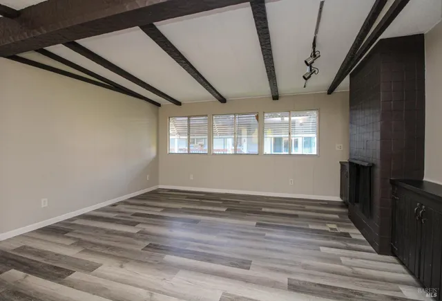 a view of a room with wooden floor and a window