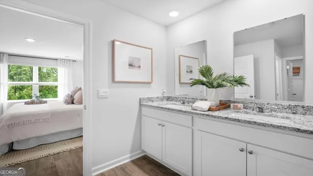 a en suite bathroom with a granite countertop double vanity and a mirror