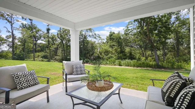 a view of a patio with couches chairs and a big yard