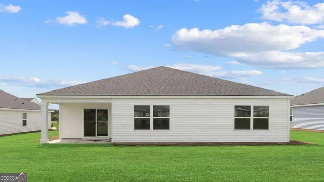 a front view of a house with a garden and yard