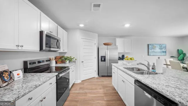 a kitchen with stainless steel appliances granite countertop a sink stove and refrigerator