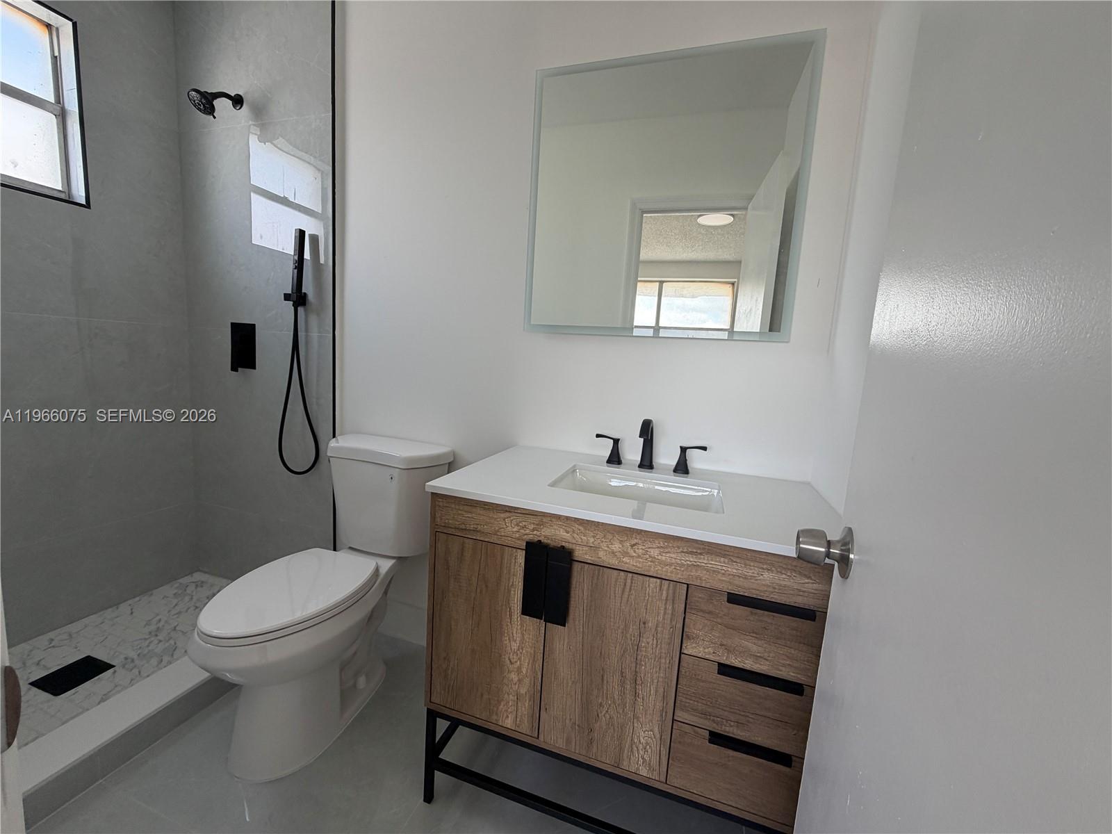 1104 West 44th Street, Unit 87 Hialeah, FL 33012 - Photo 11 of 13 a bathroom with a toilet sink and mirror
