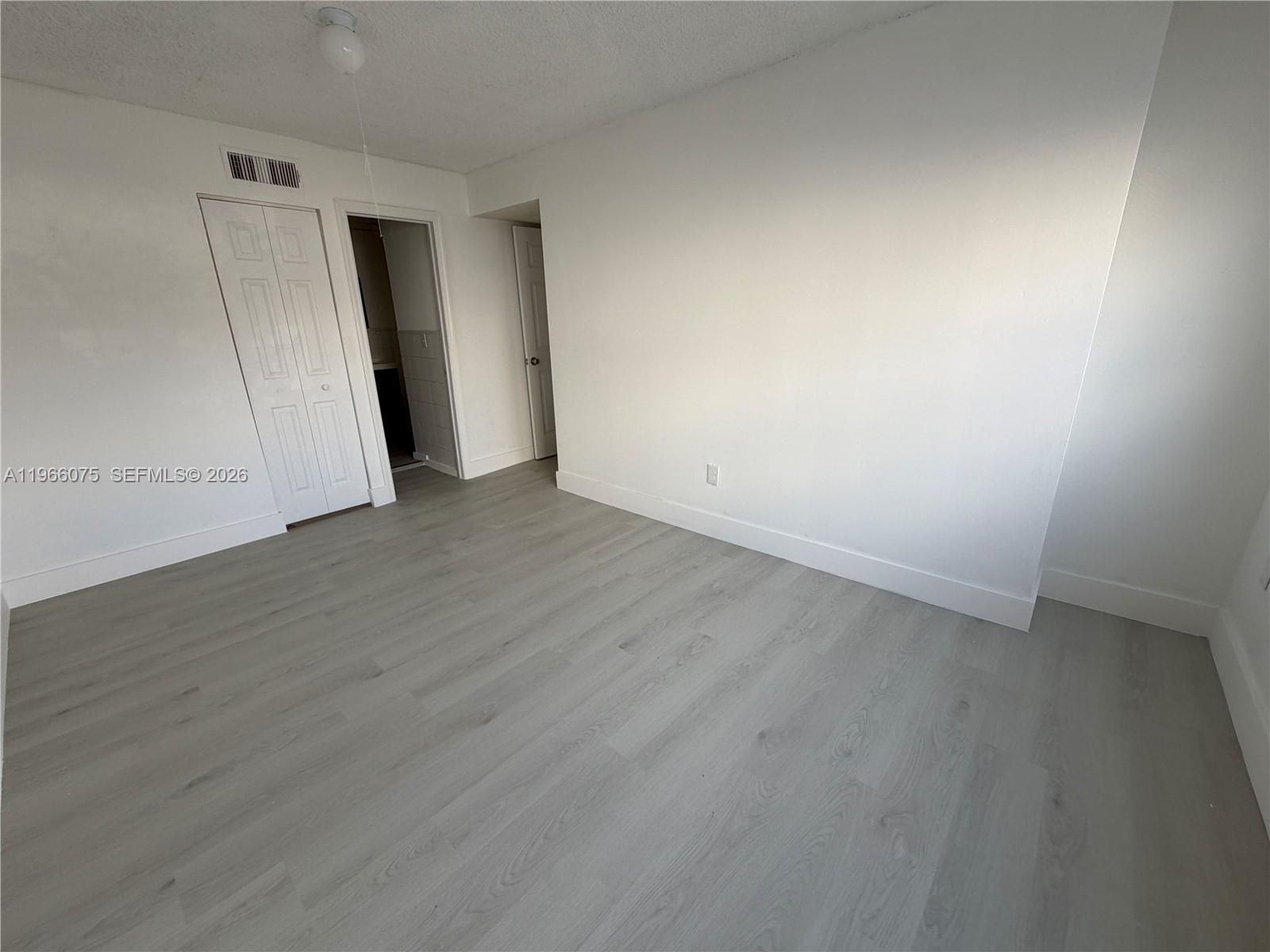 1104 West 44th Street, Unit 87 Hialeah, FL 33012 - Photo 10 of 13 an empty room with wooden floor and white doors