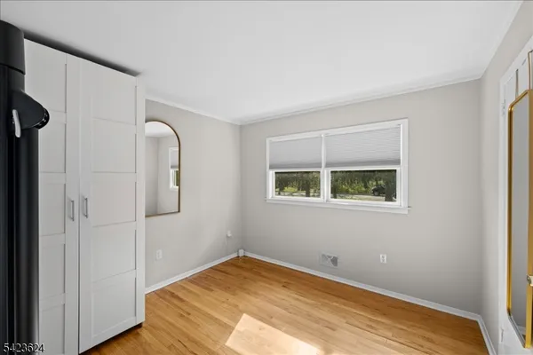 an empty room with window and wooden floor