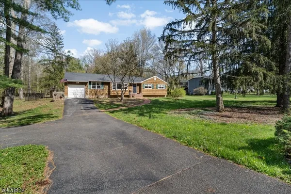 a front view of a house with a yard and trees